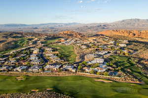 Aerial view of property and surrounding area with nearby suburban area and a mountainous background