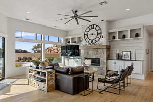 Living area featuring ceiling fan, light wood finished floors, a fireplace, recessed lighting, and a textured ceiling