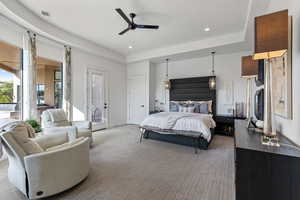 Bedroom with light carpet, a tray ceiling, access to exterior, recessed lighting, and a ceiling fan