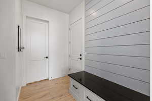 Mudroom with light wood-type flooring and baseboards