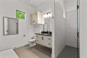 Bathroom with a stall shower, vanity, and tile patterned flooring