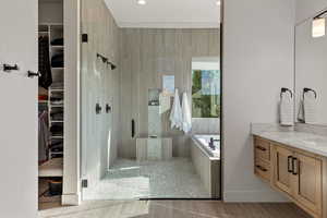 Full bath with a shower stall, a walk in closet, vanity, a garden tub, and recessed lighting