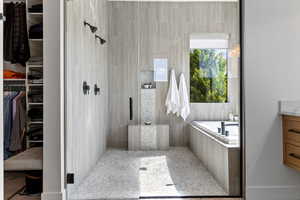 Bathroom with a stall shower, a bath, vanity, and a spacious closet