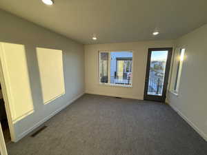 Unfurnished room with recessed lighting and dark carpet