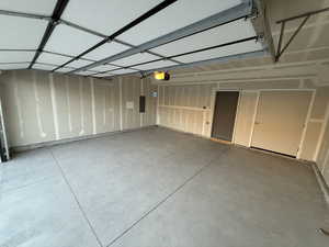 Garage with electric panel and a garage door opener