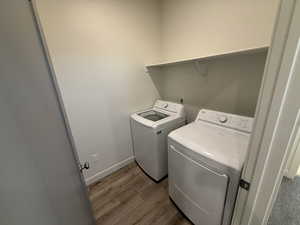 Washroom featuring independent washer and dryer and wood finished floors