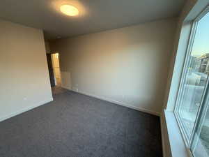 Spare room with dark colored carpet and a textured ceiling