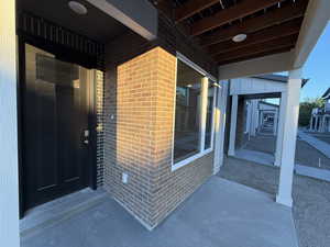 View of exterior entry featuring brick siding