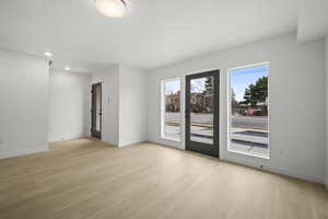 Empty room with light wood finished floors and recessed lighting