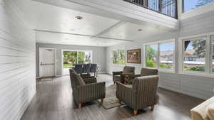 Living area featuring hardwood / wood-style floors, a textured ceiling, and wooden walls