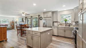 Kitchen featuring appliances with stainless steel finishes, healthy amount of natural light, a ceiling fan, a kitchen island, and recessed lighting