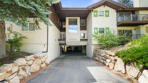 Entrance to property featuring stucco siding and driveway