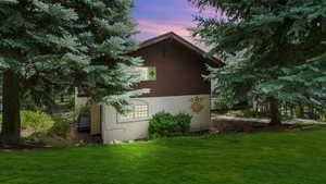 Property exterior at dusk with a yard and stucco siding