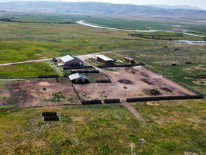 Aerial view of property and surrounding area featuring rural landscape and a mountain backdrop