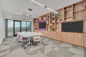 Dining space featuring light colored carpet and built in shelves