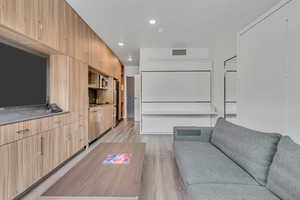 Living area with light wood-style floors and recessed lighting
