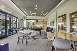 Carpeted dining area with a chandelier and built in shelves