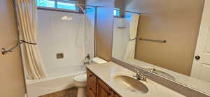 Full bath featuring shower / bath combo with shower curtain, vanity, and tile patterned flooring