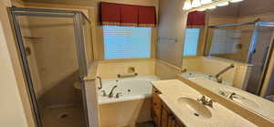 Full bathroom featuring vanity, a jetted tub, and a stall shower