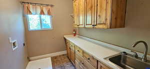 Laundry area with cabinet space, hookup for a washing machine, electric dryer hookup, and tile patterned flooring