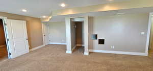 Below grade area featuring light colored carpet and recessed lighting