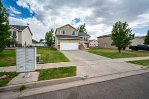 Traditional-style home with brick siding, an attached garage, and concrete driveway