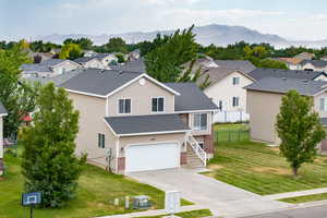 View of front facade with concrete driveway, an attached garage, a residential view, and a mountain view
