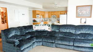 Living area featuring ceiling fan and carpet floors