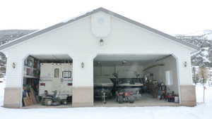 Snow covered garage with a detached garage and a mountain view