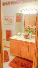 Bathroom with double vanity, tile patterned floors, and a shower