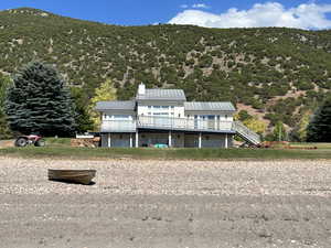 View of front of property with a metal roof, a deck with mountain view, stairs, and a chimney