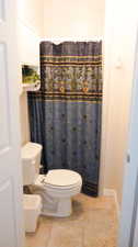 Bathroom with tile patterned flooring and curtained shower