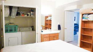 Bedroom with washing machine and clothes dryer and a sink