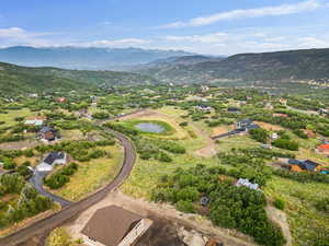 Aerial view of property and surrounding area with a mountain backdrop
