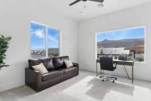 Office area with a ceiling fan, carpet, and a mountain view