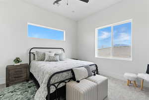 Carpeted bedroom with a ceiling fan and baseboards