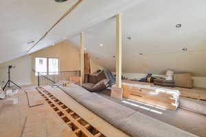 Living area featuring lofted ceiling above garage