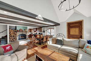 Living area featuring light wood-style flooring, recessed lighting, a fireplace, and beam ceiling
