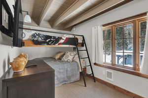 Carpeted bedroom featuring baseboards and a wood ceiling with exposed beams