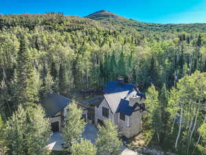 Aerial view of property and surrounding area featuring a forest