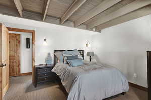 Bedroom featuring carpet floors and beam ceiling