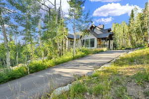 View of front of house featuring asphalt driveway and a chimney