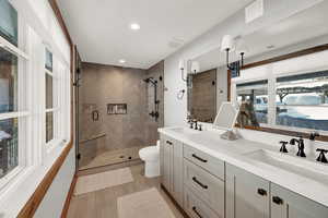 Bathroom featuring a stall shower, double vanity, and recessed lighting