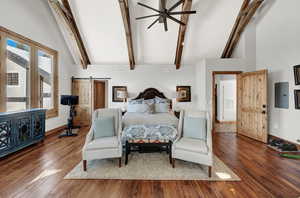 Bedroom featuring a high vaulted ceiling, wood finished floors, and beam ceiling