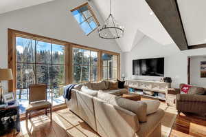 Living room featuring a chandelier, high vaulted ceiling, and wood finished floors
