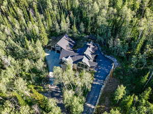 Aerial view of property and surrounding area with a heavily wooded area