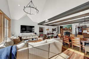 Living room with a chandelier, wood finished floors, high vaulted ceiling, and recessed lighting