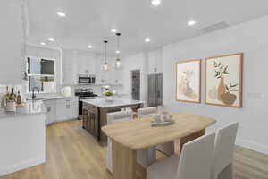Kitchen featuring stainless steel appliances, light countertops, white cabinetry, a kitchen island, and recessed lighting