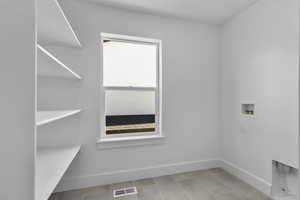 Laundry area with hookup for a washing machine and tile patterned flooring