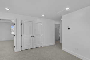 Unfurnished bedroom with carpet floors, a closet, and recessed lighting